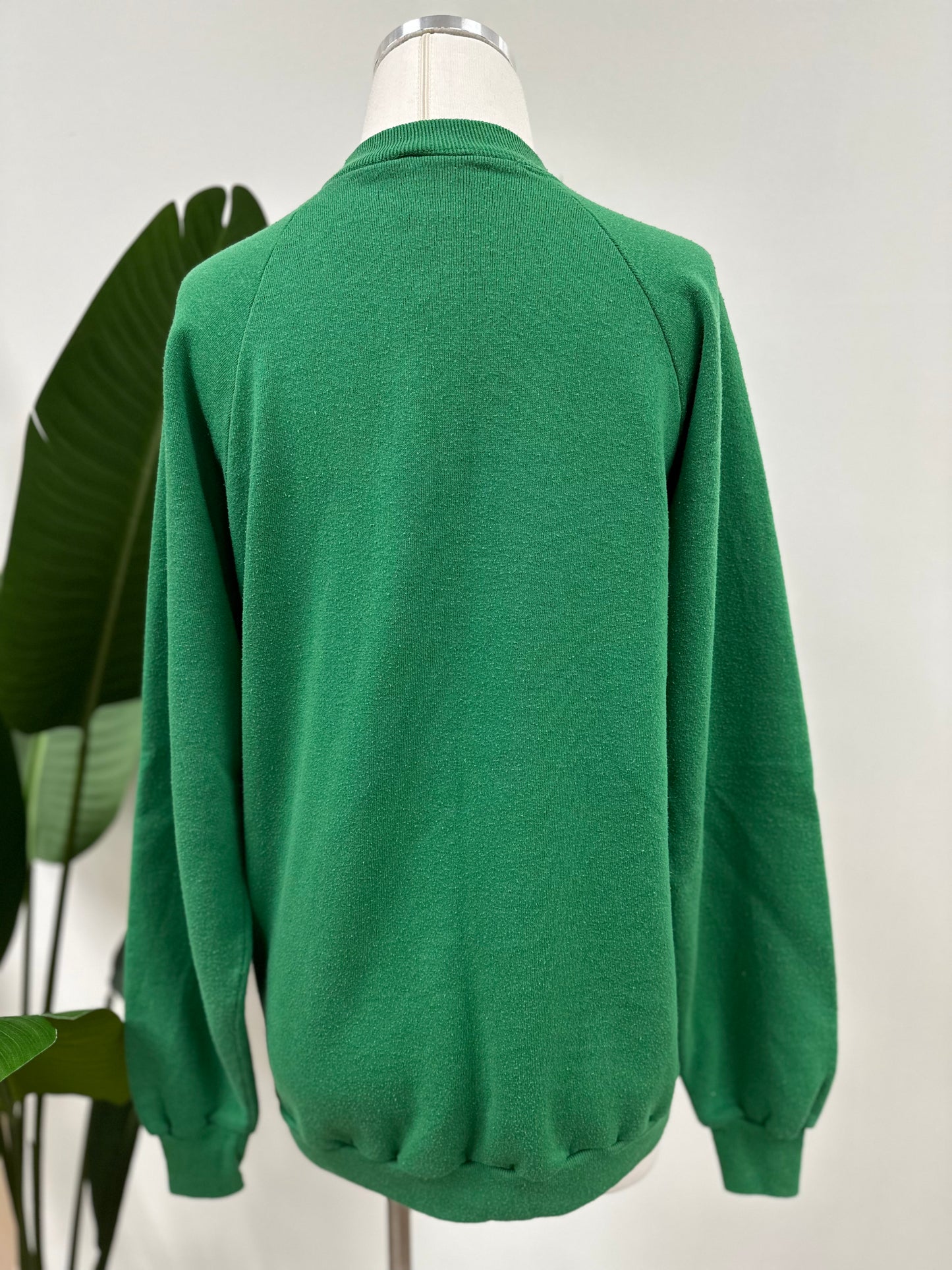Back view of a kelly green vintage crewneck with a white embroidered Super Bowl Score