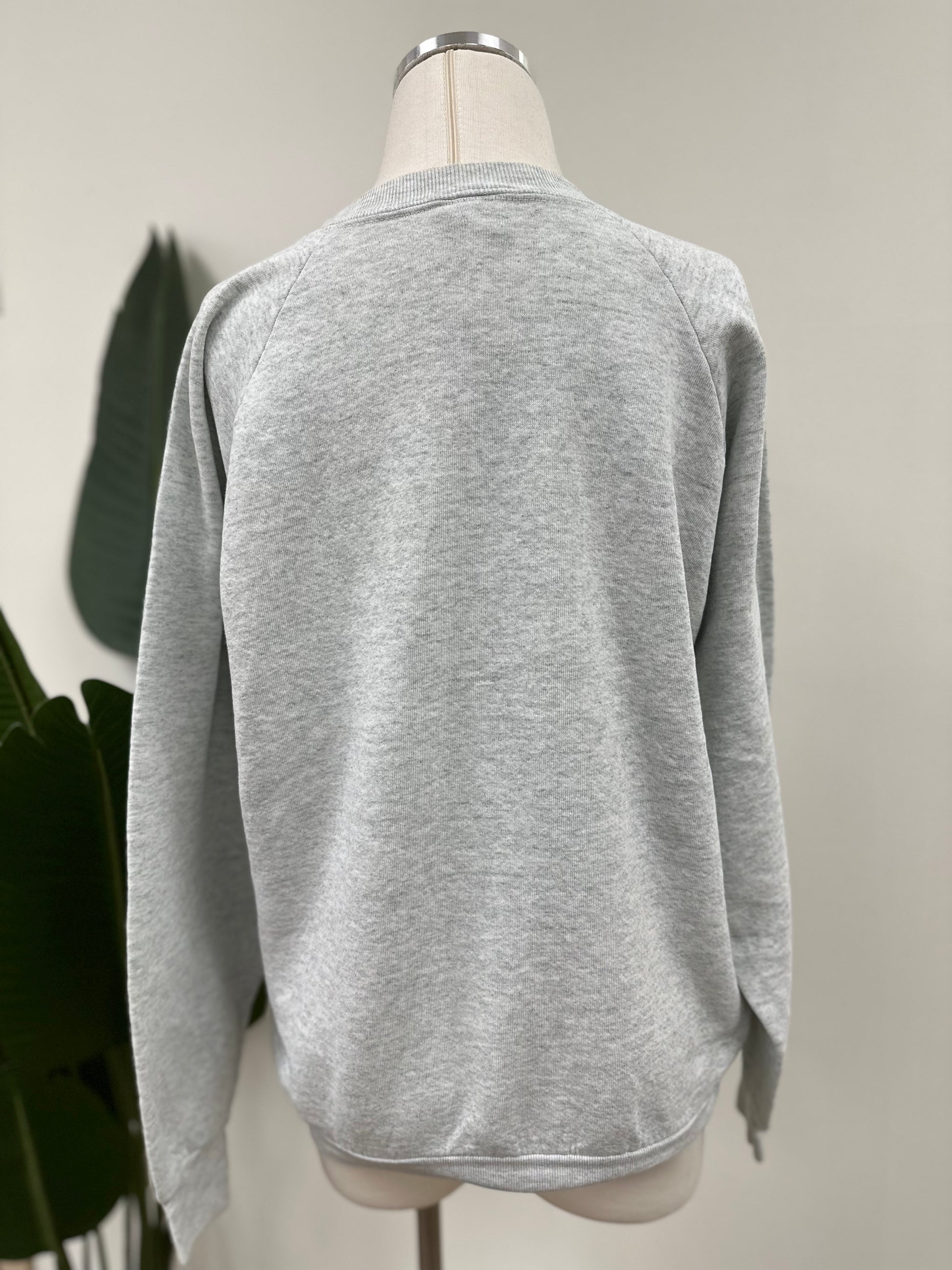 Back view of a heather grey vintage crewneck with green bird gang embroidery