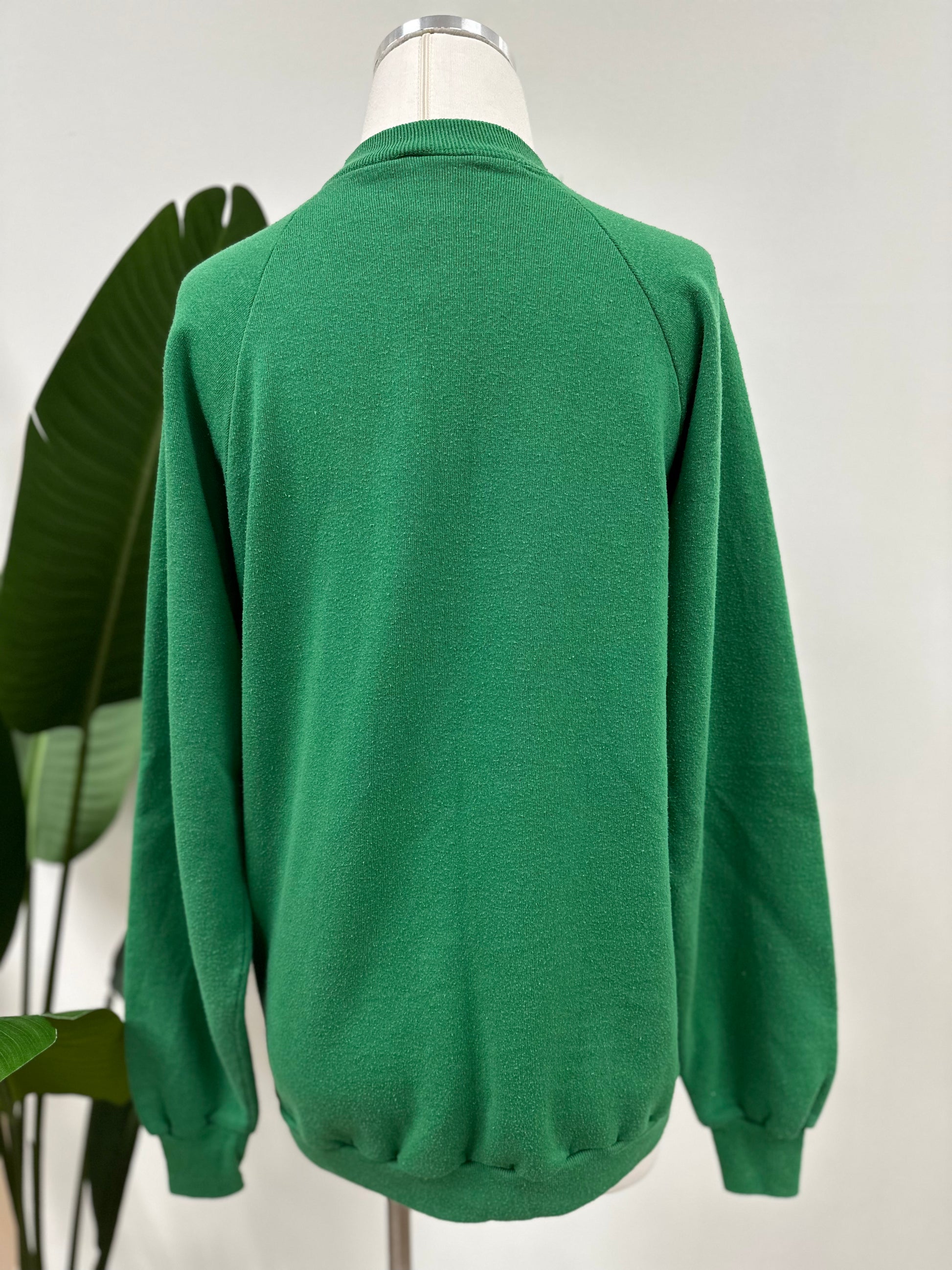 Back view of a kelly green vintage crewneck with a white embroidered Super Bowl Score